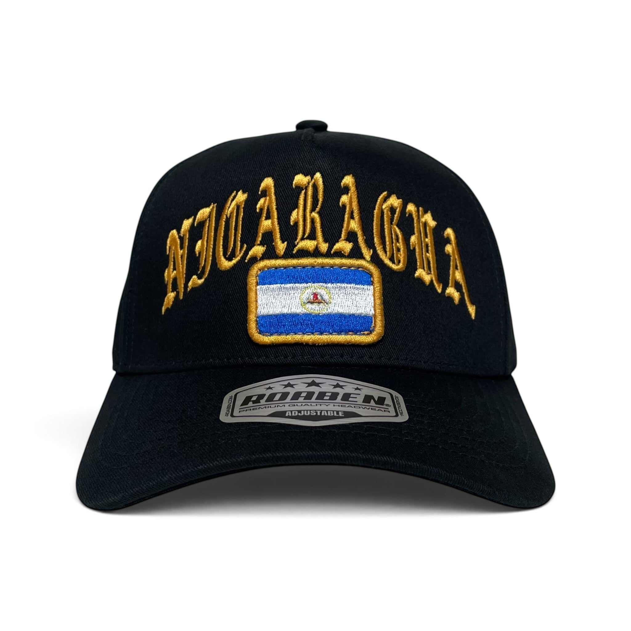 A black baseball cap featuring gold embroidered 'NICARAGUA' text and a rectangular patch of the Nicaraguan flag on the front. 