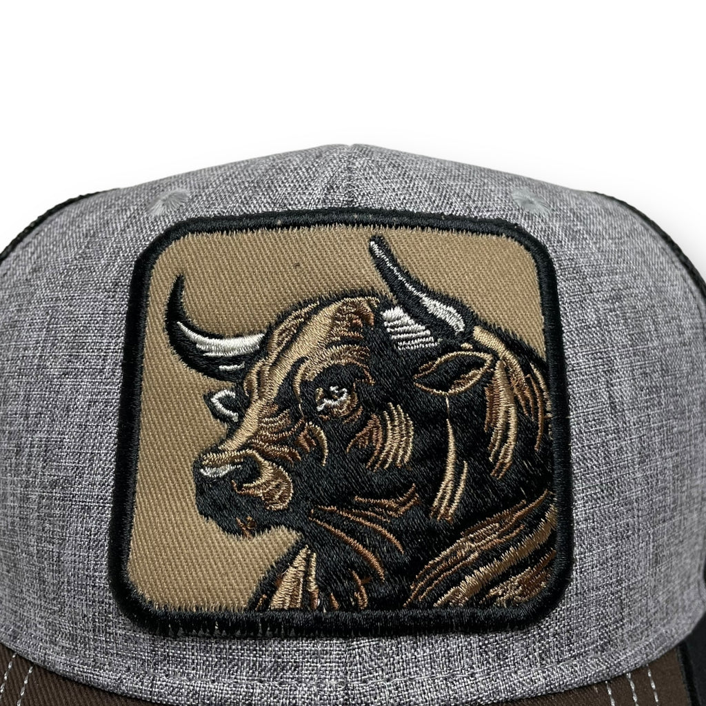 Close-up of embroidered bull patch on gray snapback hat