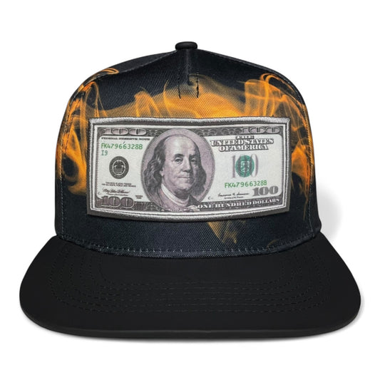 Black snapback cap with 100 dollar bill embroidered patch on the front, flat brim, adjustable closure, streetwear style.