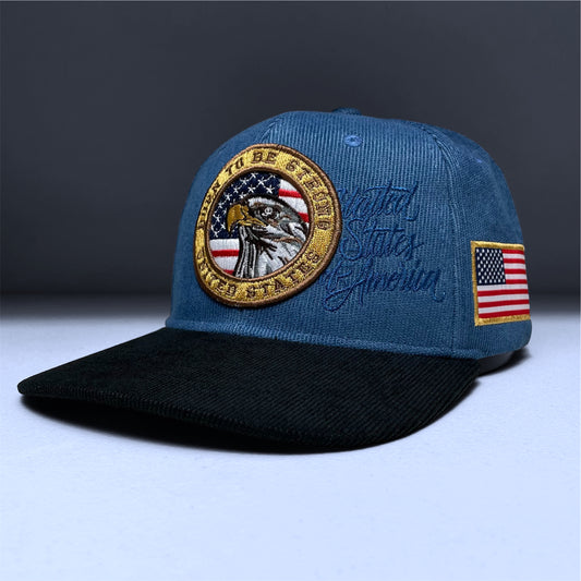 Blue corduroy snapback cap with embroidered USA flag and eagle design on the front panel.
